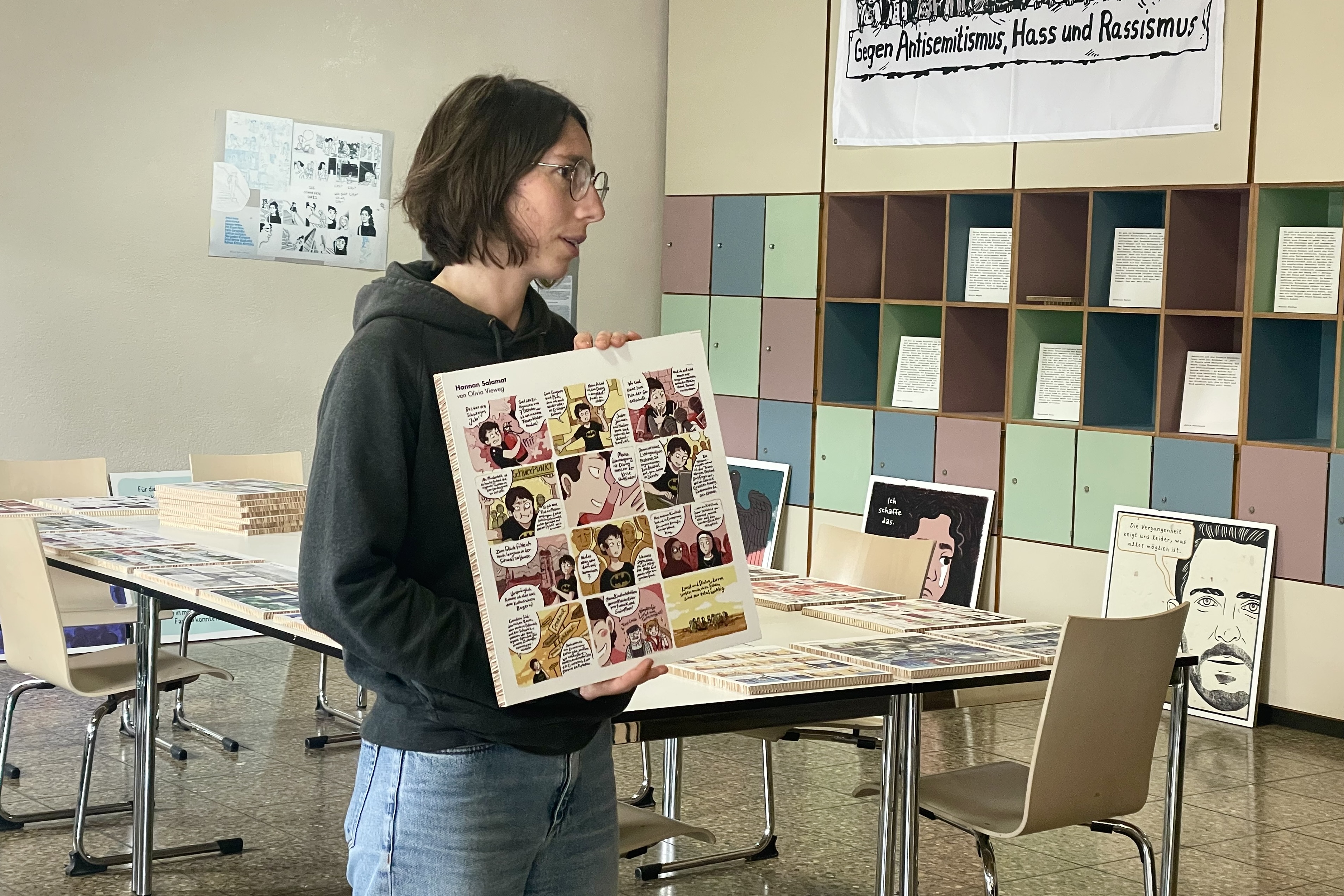 Eine Frau zeigt eine Tafel mit einem Comic.